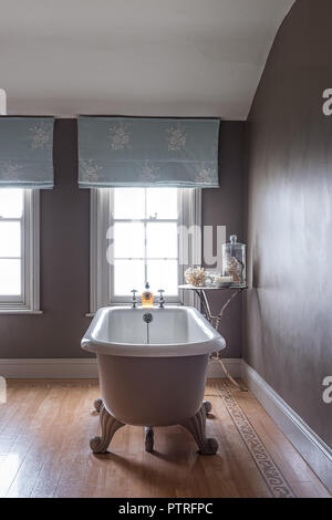 Ferme du 16ème siècle rénovation baignoire sur pieds avec emboidered à rideaux bleu clair dans la fenêtre ferme du xvie siècle restauré Banque D'Images