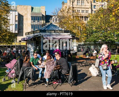 Princes Street Gardens, Édimbourg, Écosse, Royaume-Uni, 10 octobre 2018. Météo France : La température a augmenté à un temps chaud 18 à 20 degrés dans le centre-ville. Profitez des gens assis dans le soleil chaud parmi les arbres d'automne les couleurs. Une femme mange un cornet de crème glacée Banque D'Images