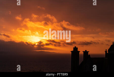 Lyme Regis, dans le Dorset, UK. 11 octobre 2018. Météo France : toits dans le quartier historique de la ville de Lyme Regis sont silhouetté contre moody ciel comme les nuages de tempête orange glow au lever du soleil sur ce qui est défini pour être un jour pluvieux et venteux à Lyme Regis. Credit : PQ/Alamy Live News Banque D'Images