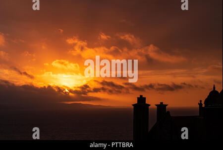 Lyme Regis, dans le Dorset, UK. 11 octobre 2018. Météo France : toits dans le quartier historique de la ville de Lyme Regis sont silhouetté contre moody ciel comme les nuages de tempête orange glow au lever du soleil sur ce qui est défini pour être un jour pluvieux et venteux à Lyme Regis. Credit : PQ/Alamy Live News Banque D'Images