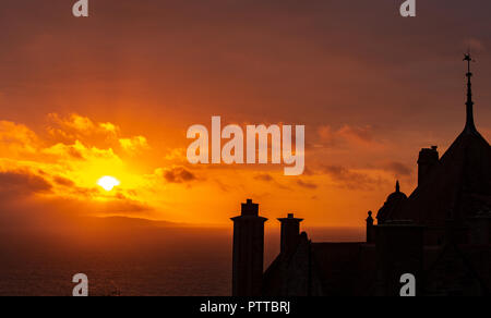 Lyme Regis, dans le Dorset, UK. 11 octobre 2018. Météo France : toits dans le quartier historique de la ville de Lyme Regis sont silhouetté contre moody ciel comme les nuages de tempête orange glow au lever du soleil sur ce qui est défini pour être un jour pluvieux et venteux à Lyme Regis. Credit : PQ/Alamy Live News Banque D'Images