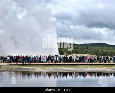 05.07.2018, USA, Canyon Village : touristes visitent l'éruption du geyser Old Faithful, dans la partie sud-ouest du parc. Centre d'accueil pendant les heures d'ouverture, les statistiques et les prévisions sont geyser créé par les naturalistes. Les intervalles de l'éclosion, qui dure entre 1,5 et 5 minutes, peut être compris entre 60 et 110 minutes. A Yellowstone cinq entrées et cinq zones d'extension. La majeure partie du parc est situé dans le Wyoming, avec les petites parties du parc au nord et au nord-ouest d'être dans le Montana et l'Idaho. Photo : Soeren Stache/dpa-Zentralbild/ZB | conditions dans le monde entier Banque D'Images