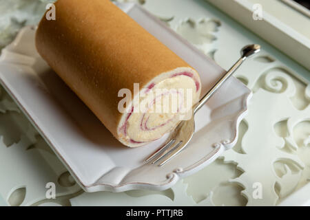 Gâteau rouleau arctique sur une plaque à côté d'une fourchette sur un bac. le dessert. Banque D'Images