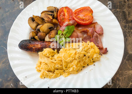 Un petit-déjeuner anglais repas Café d'oeufs brouillés et bacon saucisses frites et champignons, servi au Yorkshire Banque D'Images