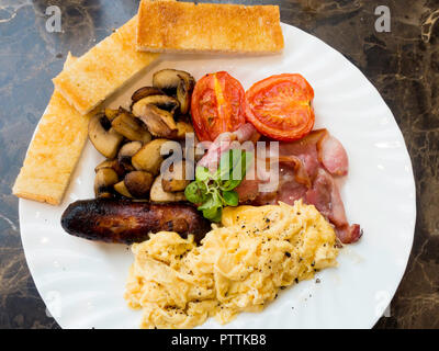 Un petit-déjeuner anglais repas Café d'oeufs brouillés et bacon saucisses frites et champignons, avec doigts de pain blanc grillé servi au Yorkshire Banque D'Images