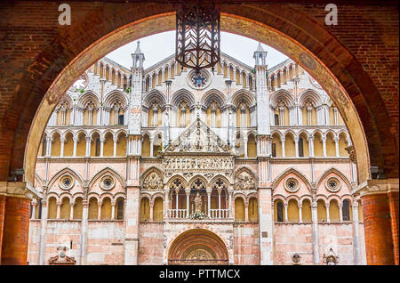 La vue sur la belle façade de Ferrara Duomo de l'arc de Palazzo Estense Duches, Italie Banque D'Images