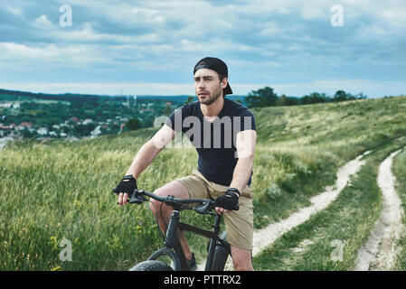 Beau mec élégant à vélo les montagnes. Vue rapprochée Banque D'Images
