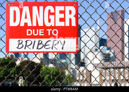 Inscrivez-danger à cause de la corruption sur la clôture à l'avant de la ville Banque D'Images