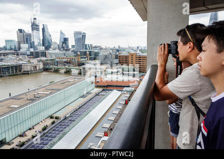 Londres Angleterre, Royaume-Uni, Bankside, Tamise, Tate art moderne musée terrasse vue, ville horizon, gratte-ciel du centre-ville, toits, ciel gris, homme asiatique hommes hommes, garçon Banque D'Images