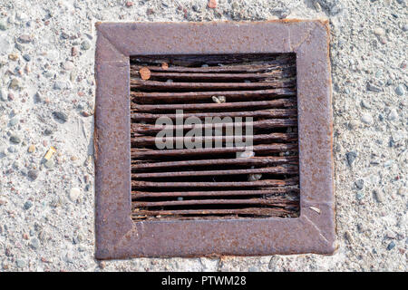 Grille de métal corrodé pour évacuer l'eau dans un sol en béton. Un lieu de rafting le long de la côte. waterwaters, saison de l'automne. Banque D'Images