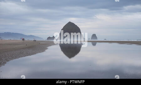 Haystack Rock reflète dans la marée piscines de Cannon Beach Oregon à marée basse extrême sur un matin nuageux. Banque D'Images