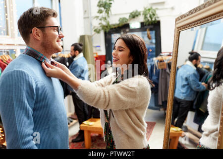 Couple choisissant des vêtements au magasin de vêtements vintage Banque D'Images