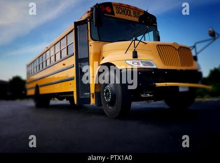 Low angle photo des autobus scolaires jaunes, vu de l'avant, droite montrant la porte et grill Banque D'Images