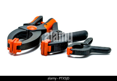 Pince à ressort noir et orange isolé sur fond blanc. Ensemble de petites, moyennes et grandes taille de collier en plastique. Outils de serrage pour les travaux de menuiserie. Ha Banque D'Images