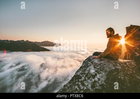 Détente homme seul sur le bord au-dessus de la montagne falaise voyage nuages vie aventure l'harmonie avec la nature vacances en Norvège Banque D'Images