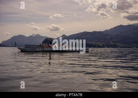 Menaggio, Italy-April 2, 2018 Concordia : ferry boat sur le lac de Côme le transport de personnes sur la montagne en arrière-plan Banque D'Images