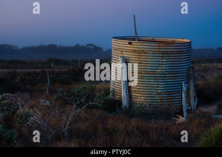 Tôle ondulée rouillée près du réservoir d'eau de pluie sur les ruines de la ferme tôt le matin léger vers Ceduna Australie du Sud Banque D'Images