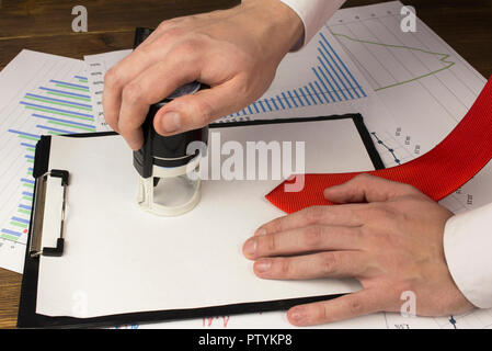 La main d'un homme met un joint sur une feuille blanche, une cravate, une loupe Banque D'Images