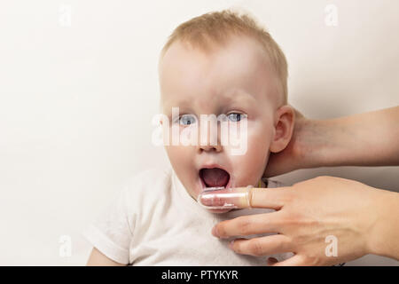 Une petite fille se nettoie les dents, fond blanc, close-up Banque D'Images