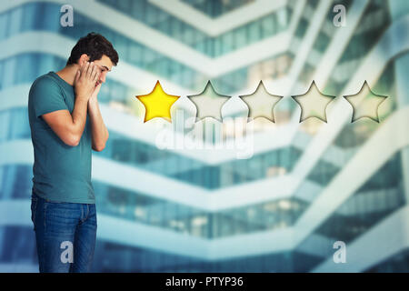 Vue latérale d'un jeune homme déçu et a souligné les mains sur les joues en regardant le choix d'un classement par étoiles. Mauvais service à la clientèle faible et concept. Negat Banque D'Images