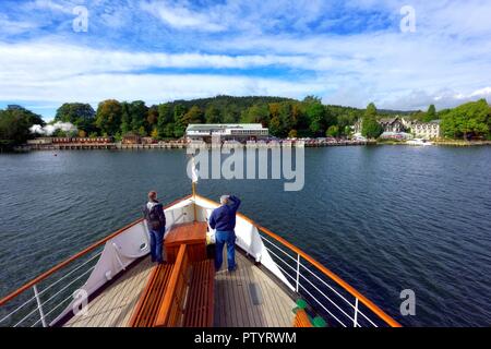 Les passagers debout sur la proue du MV,Swan Windermere lake cruises,arrivant à,au bord du lac Le lac Windermere Cumbria,Angleterre,,UK Banque D'Images