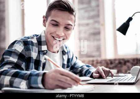 Cheerful student et avoir la bonne humeur alors que la prise de notes Banque D'Images