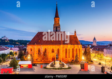 Cluj, Roumanie. L'Église médiévale et Union Square au lever du soleil. Banque D'Images