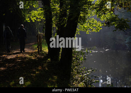 Deux ramblers se promènent le matin ensoleillé d'octobre le long du canal Ripon, dans le North Yorkshire, Angleterre, Royaume-Uni. Banque D'Images