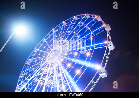 Carnival ride montrant une grande roue tourne en action- longue exposition shot. Banque D'Images