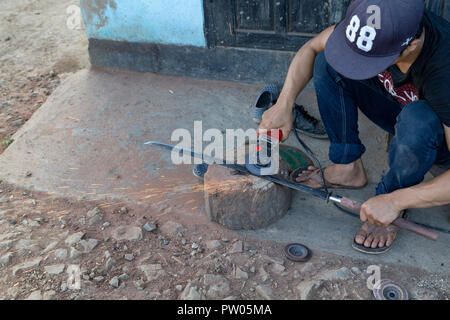 LUANG PRABANG, LAOS - 8 octobre : un homme non identifié moud une épée à une forge à Luang Prabang, Laos le 8 octobre 2017. Banque D'Images