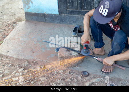 LUANG PRABANG, LAOS - 8 octobre : un homme non identifié envoie des étincelles voler à une forge à Luang Prabang, Laos le 8 octobre 2017. Banque D'Images