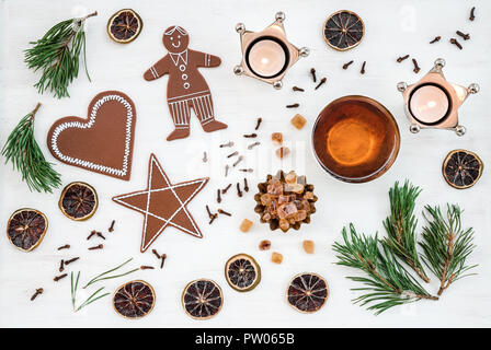 Décoration de Noël nordique avec des bougies, thé et biscuits au gingembre, sur fond blanc. Banque D'Images