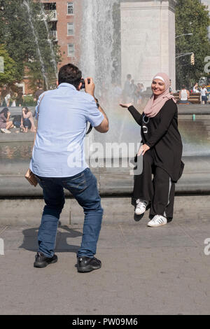 Une femme musulmane dans un hijab pose pour une photo près de la fontaine à Washington Square Park à Manhattan, New York City. Banque D'Images