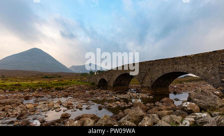 L'ancien pont de Sligachan Cuillin noires avec des montagnes en arrière-plan et nuages, île de Skye, Écosse Banque D'Images