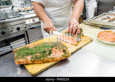 Couper en tranches un gros filet de saumon délicieux dans un restaurant Banque D'Images