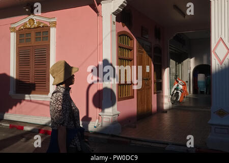 Un touriste en tenant une soirée promenade à travers soi Rommani joliment restauré et Thalang Road dans le quartier de la vieille ville de Phuket, Thaïlande Banque D'Images
