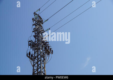Tour en acier de type treillis sur des fragments de ciel bleu comme une partie de la ligne à haute tension. Détails ligne électrique aérienne Banque D'Images