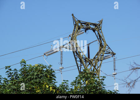 Tour en acier de type treillis sur des fragments de ciel bleu comme une partie de la ligne à haute tension. Détails ligne électrique aérienne Banque D'Images