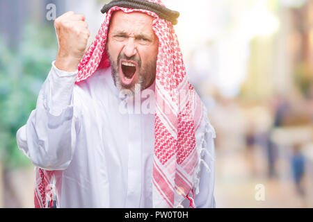 Arabe Senior homme portant un keffieh sur fond isolé en colère et frustrés et poing de fou furieux tout en criant avec colère. Rage et aggres Banque D'Images