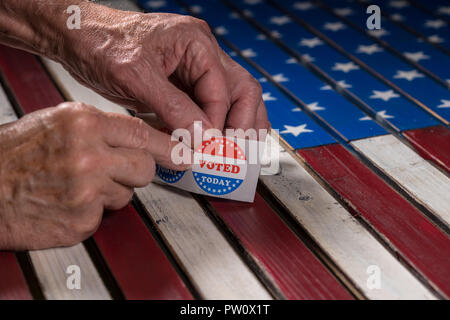 Rouleau de papier autocollants J'ai voté aujourd'hui sur US Flag avec le retrait d'une main Banque D'Images