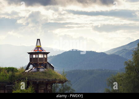Magnifique coucher de soleil avec des nuages sur les montagnes de Dachstein, lookout en bois vert avec toit de chaume en premier plan, Alpes Calcaires du Nord, Schladming, Banque D'Images