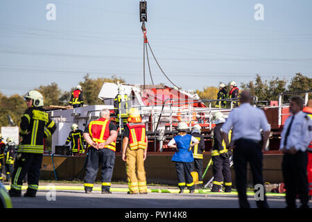 Rhine-Herne canal, Hannover, Allemagne. 11Th Oct 2018. Les pompiers tentent de soulever le détruit un cargo de timonerie à l'aide d'une grue. Après le grave accident de bateau sur le Canal de Rhine-Herne à Castrop-Rauxel, les pompiers veut utiliser de l'équipement lourd pour libérer le skipper piégés sous les décombres. Le navire avait heurté le pont à midi pour des raisons inconnues tout en passant sous un pont routier avec la timonerie. 'L'ensemble de la cabine du conducteur a été démolie," a déclaré le porte-parole. Photo : Marcel Kusch/dpa dpa : Crédit photo alliance/Alamy Live News Banque D'Images