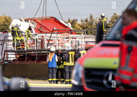 Rhine-Herne canal, Hannover, Allemagne. 11Th Oct 2018. Les pompiers tentent de soulever le détruit un cargo de timonerie à l'aide d'une grue. Après le grave accident de bateau sur le Canal de Rhine-Herne à Castrop-Rauxel, les pompiers veut utiliser de l'équipement lourd pour libérer le skipper piégés sous les décombres. Le navire avait heurté le pont à midi pour des raisons inconnues tout en passant sous un pont routier avec la timonerie. 'L'ensemble de la cabine du conducteur a été démolie," a déclaré le porte-parole. Photo : Marcel Kusch/dpa dpa : Crédit photo alliance/Alamy Live News Banque D'Images