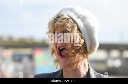 Brighton UK 12 octobre 2018 - Une femme a des problèmes avec ses cheveux alors qu'elle bénéficie d'une promenade sur le front de mer de Brighton, ce matin, à des vents forts que Storm Callum balaie certaines parties de la Grande-Bretagne aujourd'hui Crédit : Simon Dack/Alamy Live News Banque D'Images