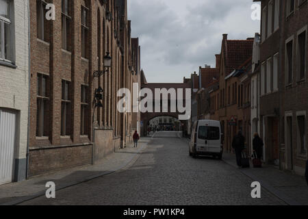 Bruges, Belgique - 17 avril : les touristes à pied il passage supérieur en faisant glisser leurs valises le 17 juin 2017 sur un jour nuageux Banque D'Images