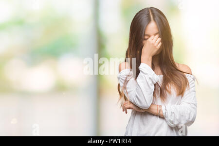 Young Asian Woman sur fond isolé fatigué se frottant le nez et les yeux sentant la fatigue et les céphalées. Le stress et la frustration concept. Banque D'Images