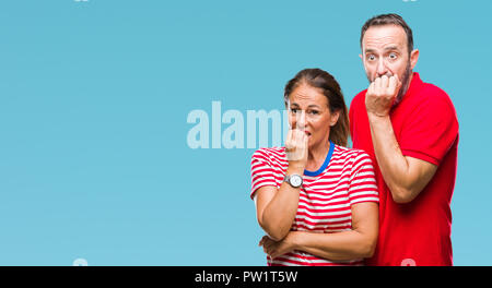 L'âge moyen hispanic couple dans l'amour sur fond isolé à souligné et nerveux avec les mains sur la bouche de mordre les ongles. Problème d'anxiété. Banque D'Images