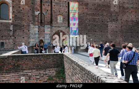 Les gens qui entrent dans l'une des portes sur l'ancien fossé à Milan, le château des Sforza (Italien : Castello Sforzesco). Il a été construit au 15ème siècle par Franc Banque D'Images