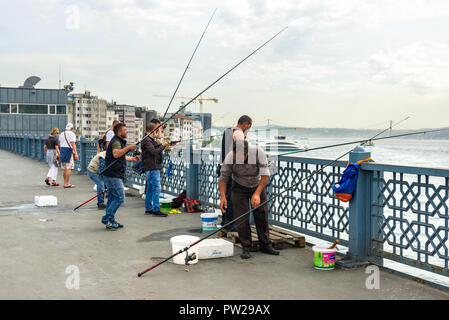 Un groupe de pêcheurs sur le pont de Galata avec leurs cannes à pêche sur le côté, Istanbul, Turquie Banque D'Images