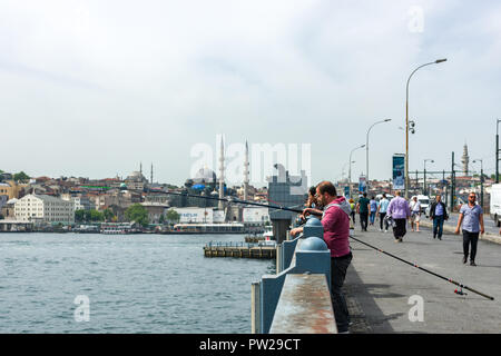 Un groupe de pêcheurs sur le pont de Galata avec leurs cannes à pêche sur le côté, Istanbul, Turquie Banque D'Images